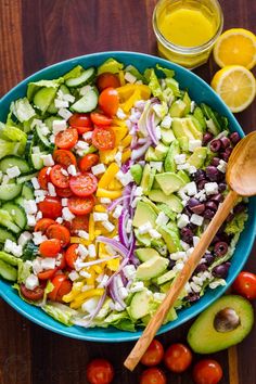 a colorful salad with avocado, tomatoes, cucumbers and olives