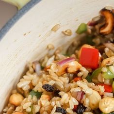 a bowl filled with rice and vegetables on top of a table