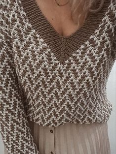 a woman wearing a brown and white sweater