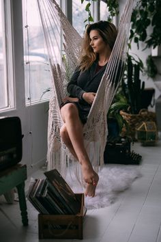 a woman sitting in a hammock with her legs crossed