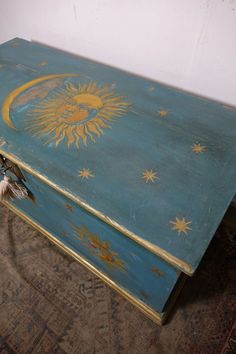 an old blue box with sun and stars painted on it