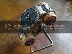 a watch and cork holder on a wooden table