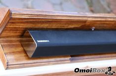 the samsung soundbar is mounted on top of a wooden shelf