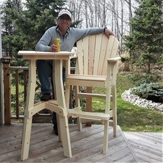 a man sitting at a table on a deck with a drink in front of him