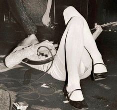 a black and white photo of a woman laying on the floor with her legs crossed