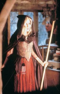 a woman dressed as a witch holding a broom