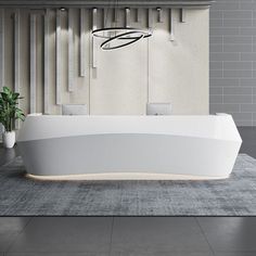 a white bath tub sitting on top of a tiled floor next to a potted plant