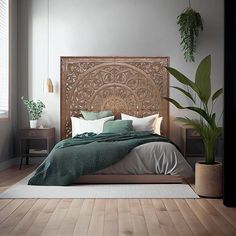 a large bed sitting on top of a wooden floor next to a potted plant