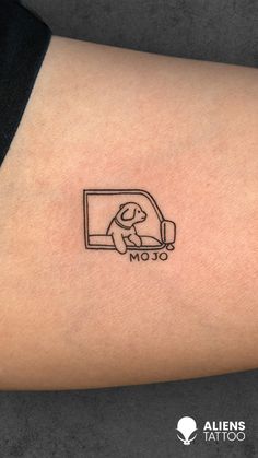 a small tattoo on the arm of a person with a dog sitting in a window