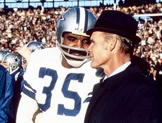 two football players standing next to each other in front of an audience at a game