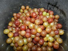 grapes are in a black bowl on the ground, ready to be picked from the garden