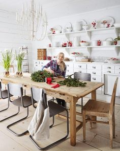 a woman sitting at a table with christmas decorations