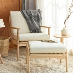 a chair and ottoman in front of a window with a basket on the floor next to it