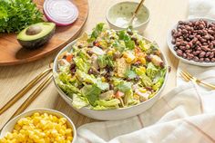 the salad is prepared and ready to be eaten with other ingredients on the table including avocado, lettuce