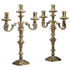 two antique brass candelabra with candlesticks on each side, possibly from the 19th century