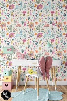 a child's desk and chair in front of a floral wallpapered wall