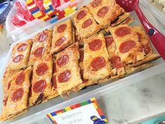 there are many slices of pepperoni pizza on the counter at this birthday cake shop