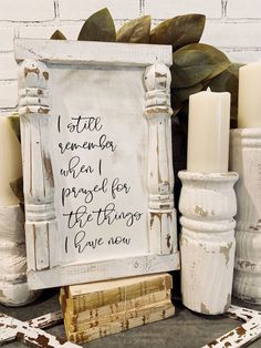 a white frame with writing on it next to some candles and other items that have been placed around