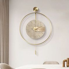 a white dining room table and chairs with a gold clock on the wall above it