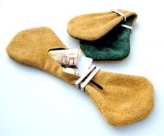 two pairs of brown and green mittens sitting next to each other on a white surface