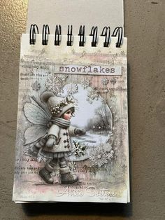 a spiral notebook with an image of a snowflakes fairy holding a hot air balloon