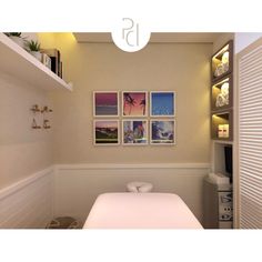 a bathroom with pictures on the wall and a white table in front of an open door