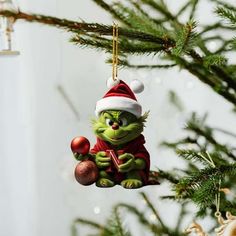 the grinch ornament is hanging from a christmas tree with ornaments on it