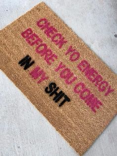 a brown door mat with pink writing on it