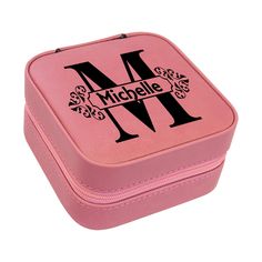 a pink lunch box with the letter m on it's front and black lettering