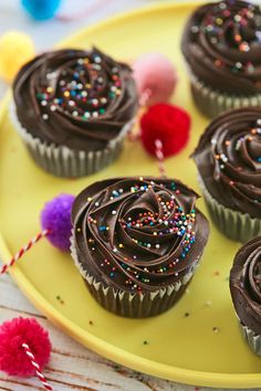 chocolate cupcakes with sprinkles on a yellow plate