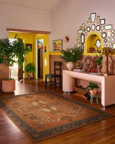 a living room filled with furniture and potted plants on top of a wooden floor