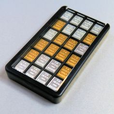 a close up of a cell phone with gold and silver squares on it