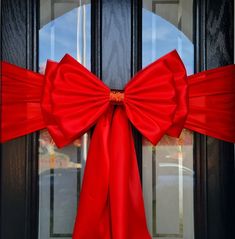 a red bow is hanging on the front door