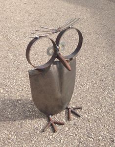 an owl statue sitting on top of a cement ground