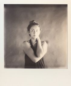 an old black and white photo of a woman with her hands on her chins