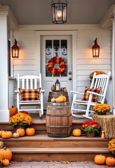 a porch decorated for fall with pumpkins and hay