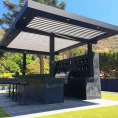 an outdoor kitchen with grill and seating area