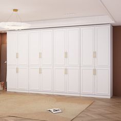 an empty room with white cupboards and carpet on the floor in front of it