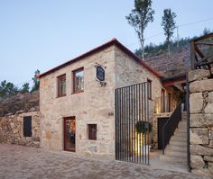 a stone building with a gate and stairs leading up to the front door is shown