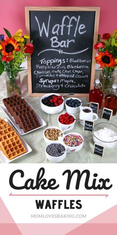 a table topped with waffles and toppings next to a chalkboard sign