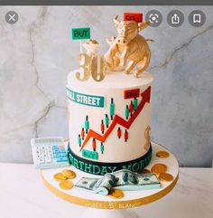 a birthday cake decorated with money and figurines on the top is an image of bull and bear