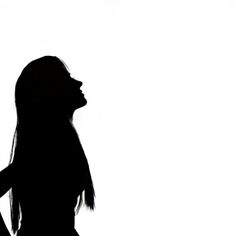 the silhouette of a woman with her hands on her hips looking up at something in the sky