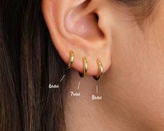 a woman's ear is shown with three different types of piercings