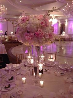 an elegant centerpiece with pink flowers and candles