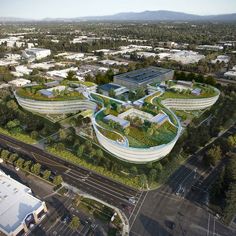 an aerial view of a building with green roofing and trees in the foreground