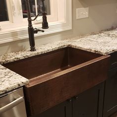 a kitchen with granite counter tops and an apron style sink in the center, under a window