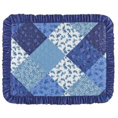 a blue and white quilted placemat with ruffled edges