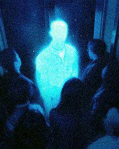 a group of people standing in front of a blue light projected on the wall behind them