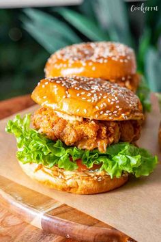 two chicken burgers sitting on top of a cutting board