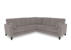 a gray sectional sofa with two pillows on it's back end and one arm facing the couch